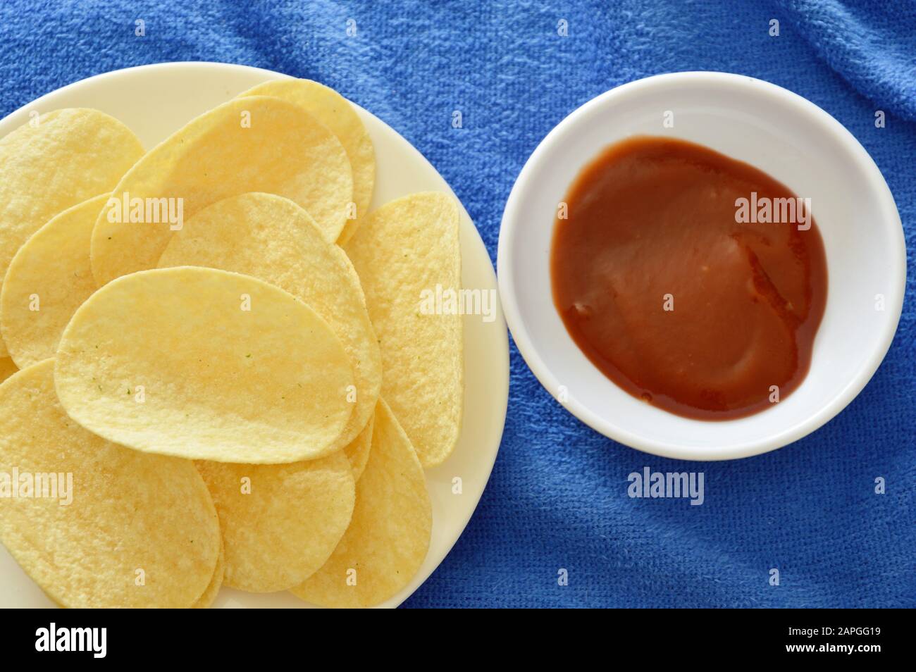 crispy and salt potato chips on dish dipping with ketchup Stock Photo