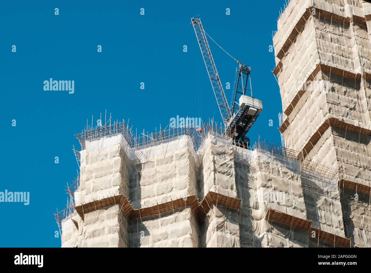 Bamboo pole scaffolding on building construction site - Stock Photo