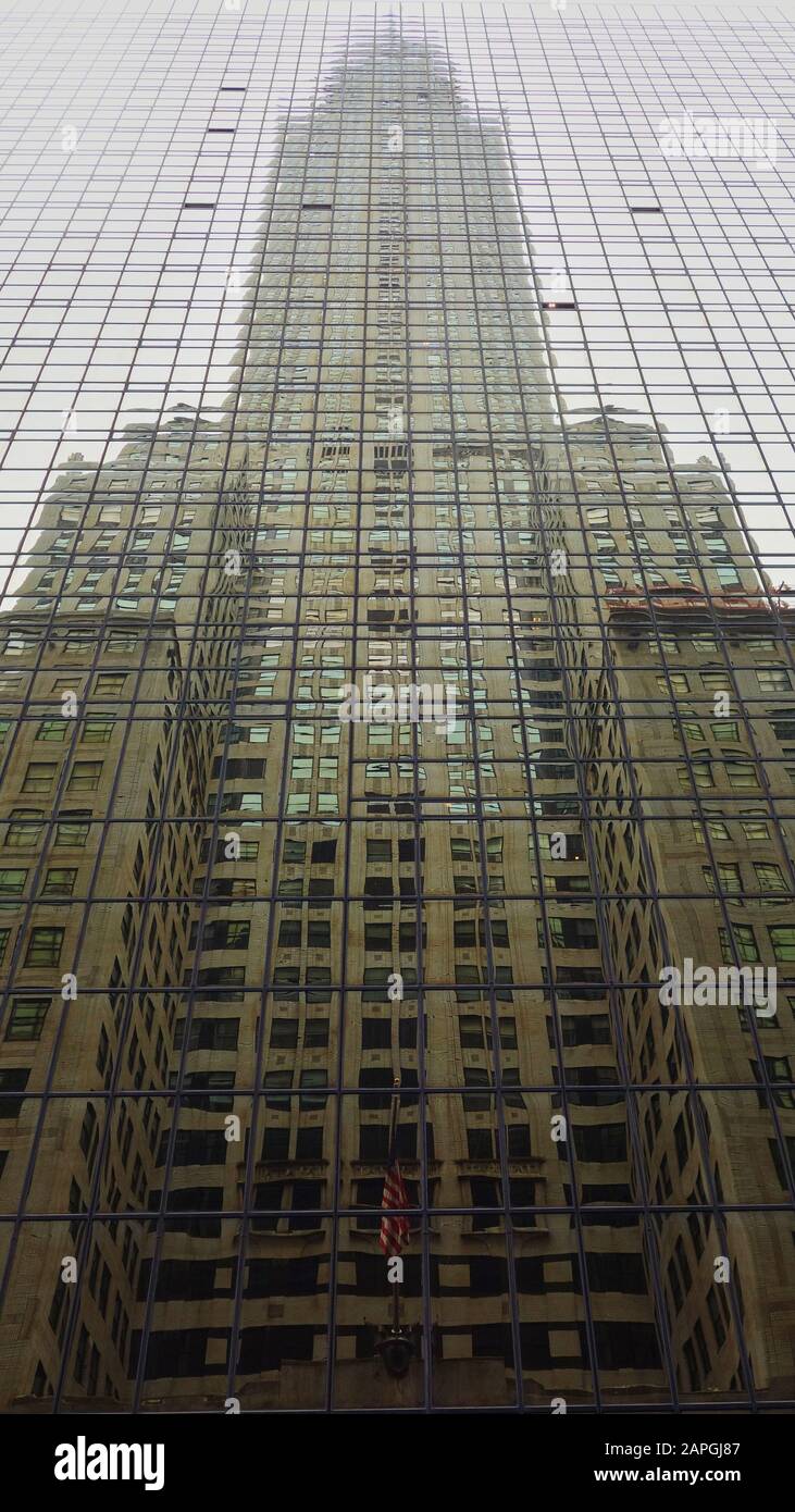 Reflection of the Chrysler Building in the Grand Hyatt Hotel on Lexington Avenue with the Stars and Stripes visible Stock Photo
