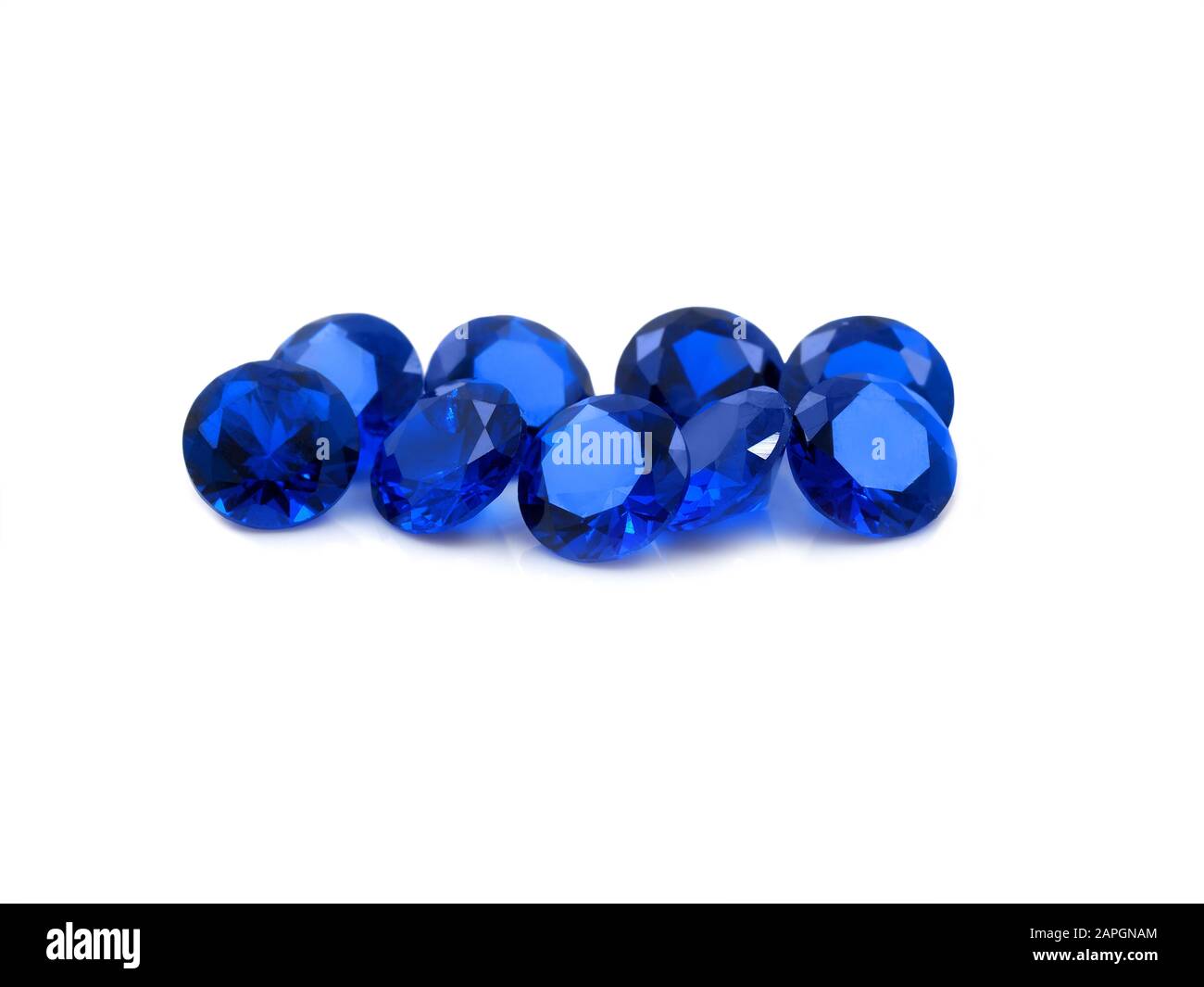Blue dimond cut sapphires on a white background. Nine deep blue faceted sapphires on a white background. Stock Photo