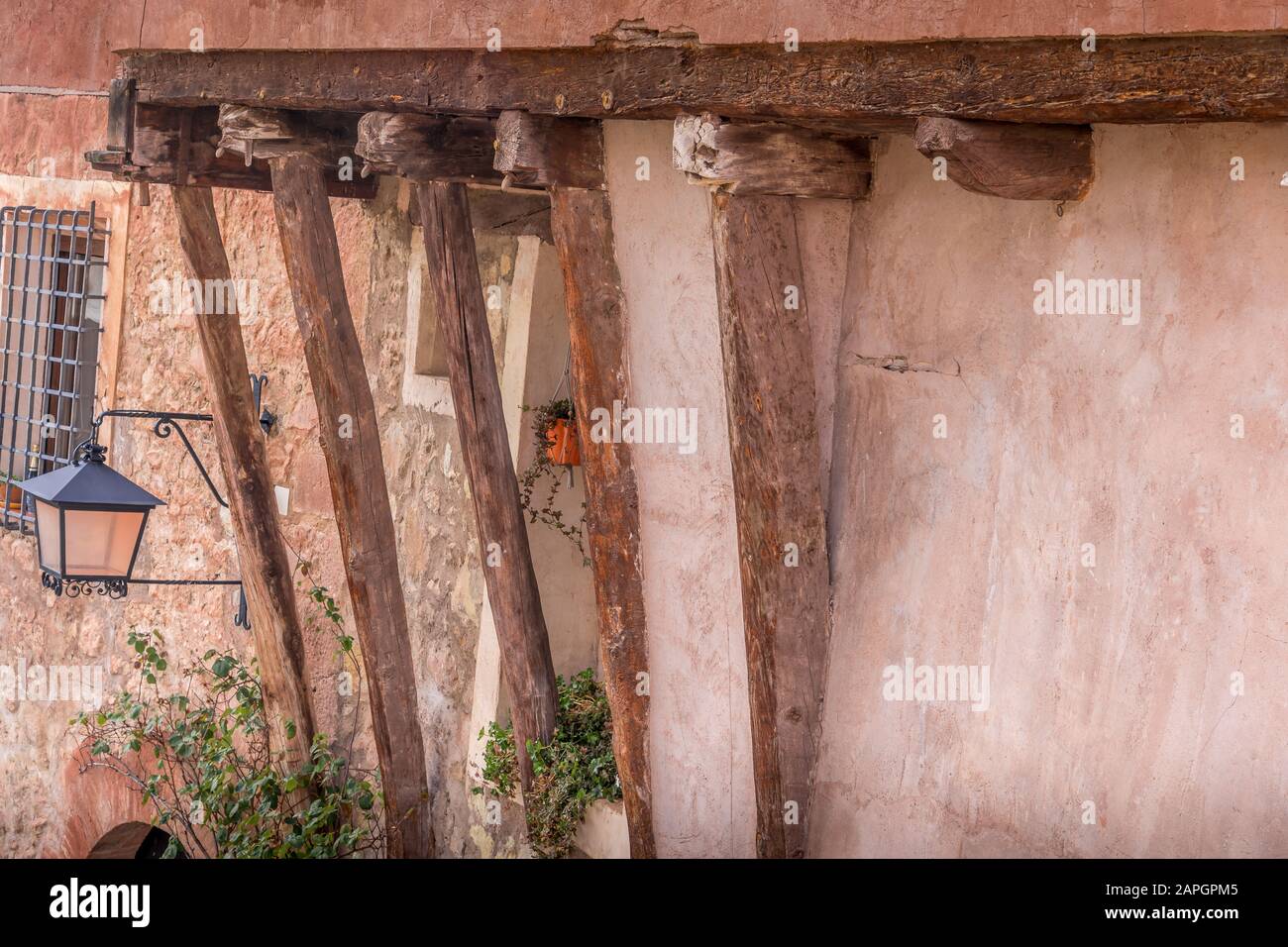 Wooden beams holding up a medieval house with red terracotta walls in Albarracin Teruel province Spain Stock Photo