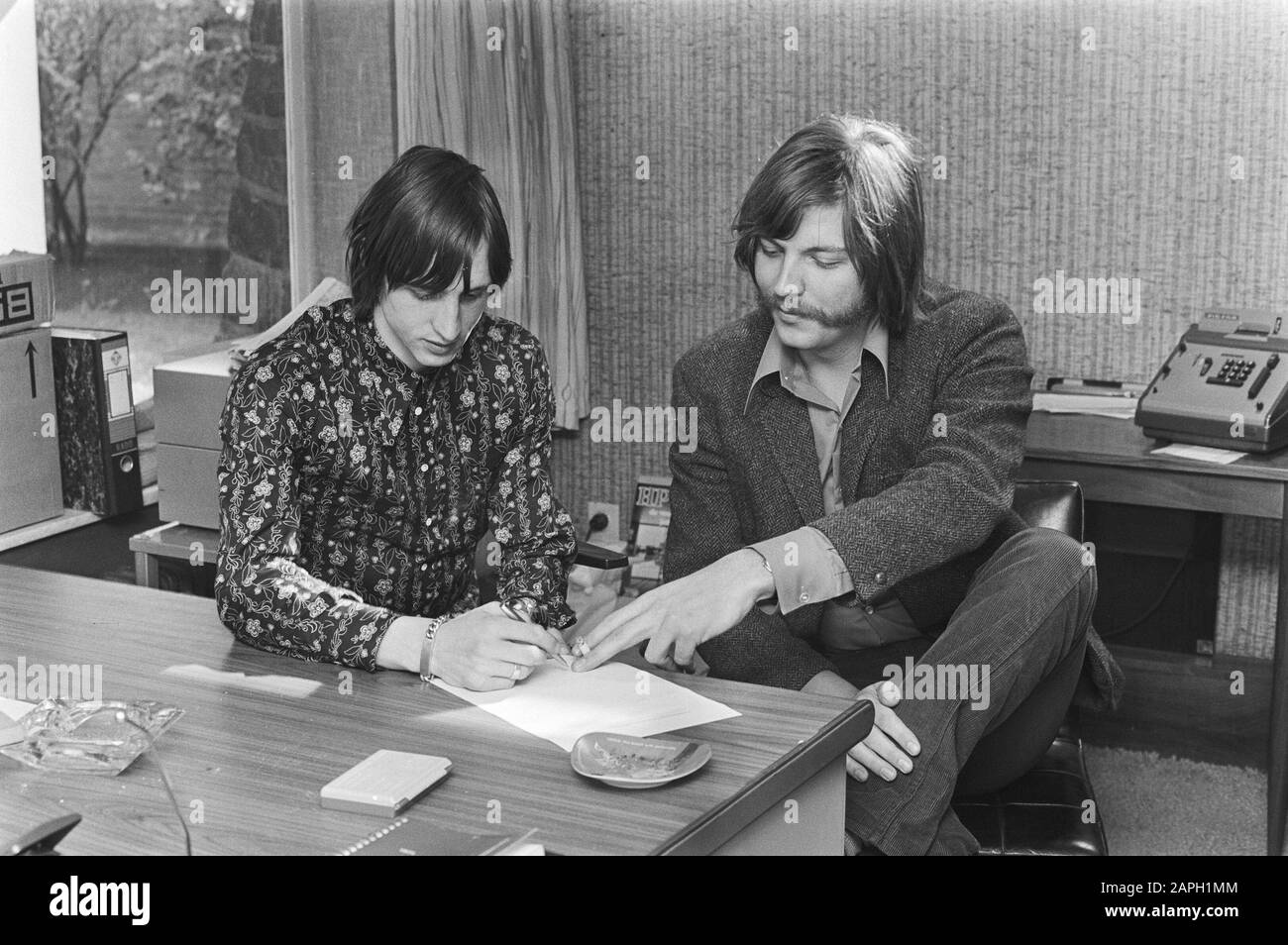 Poster of Johan Cruijff is released Description: Cruijff signs contract, right Brunst [or: Brunot], Director of Print Poster Publicity Date: March 26, 1971 Keywords: contracts, posters, sports, footballers Personal name: Cruijff, Johan Stock Photo
