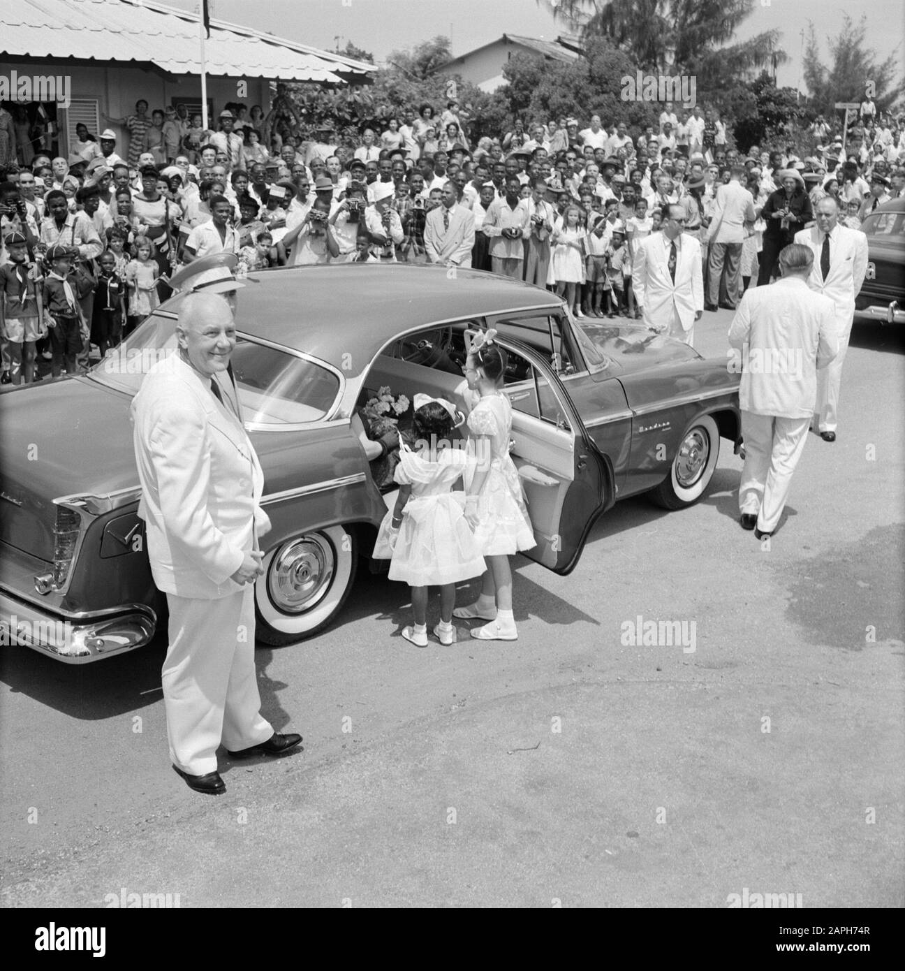 Dutch Antilles and Suriname at the time of the royal visit of Queen Juliana and Prince Bernhard in 1955 Description: The car of the royal couple at the Isla refinery in Willemstad. Left Dr. ir. H. ter Meulen Date: 21 October 1955 Location: Curaçao, Netherlands Antilles, Willemstad Keywords: cars, children, royal visits Personal name: Meulen, H. ter Stock Photo