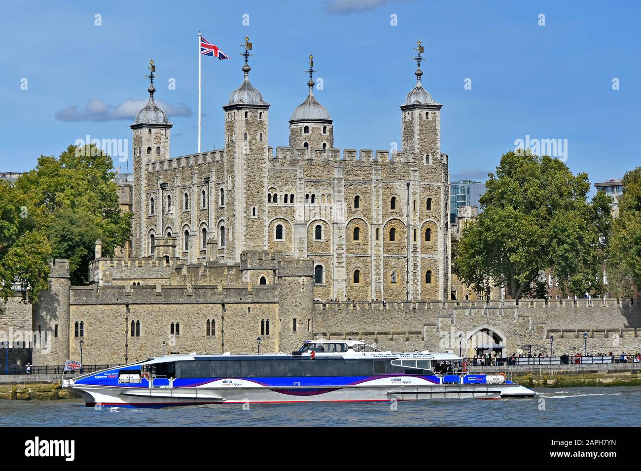 Close up of Thames clipper catamaran river bus boat on famous waterway passing historical riverside White Tower in Tower of London castle England UK Stock Photo