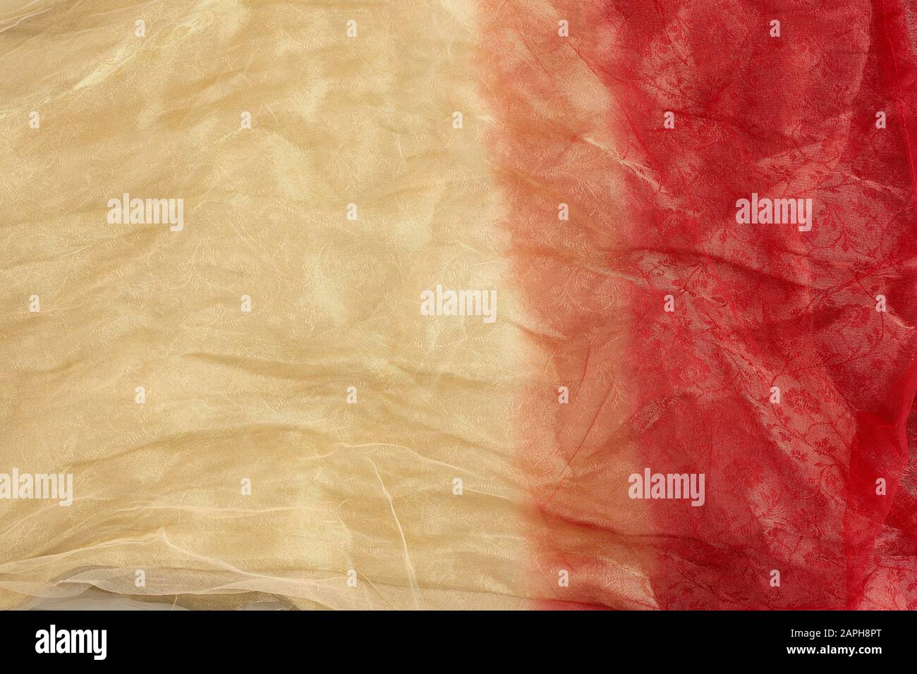 crumpled yellow-red tulle, fabric for sewing clothes, full frame, close up Stock Photo