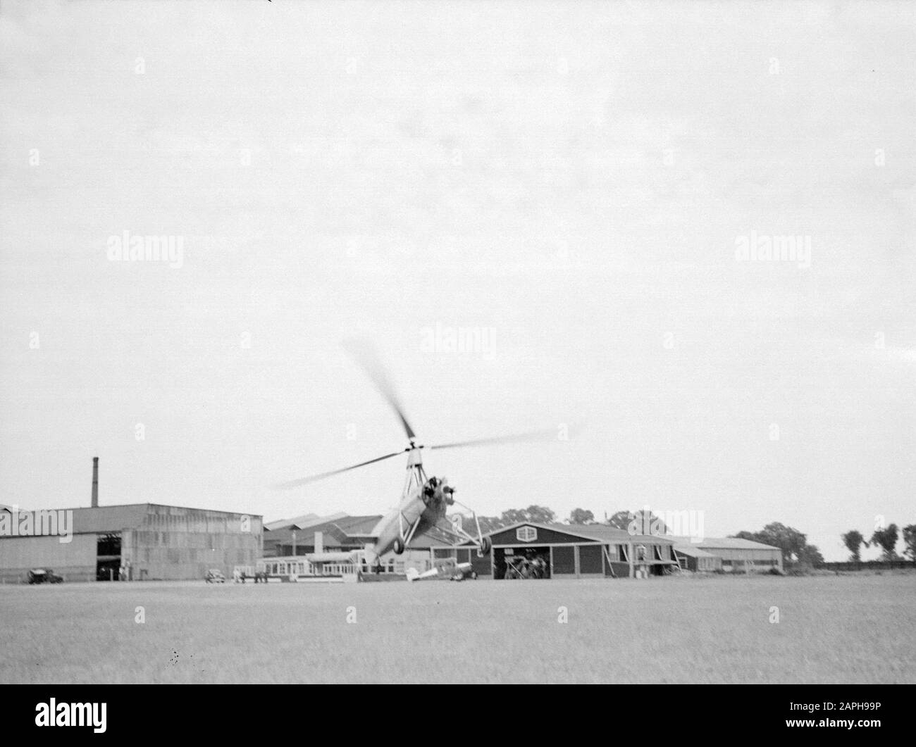 National Aviation School Holland Description: De Cierva autogiro PH-HHH called 'Donna Dulcinea' of the Dutch Aviation School flying in front of the hangars of the Rotterdam airport Waalhaven Annotation: The Dutch Aviation School was based in Rotterdam Waalhaven and Amsterdam Schiphol Date: 1935 Location: Rotterdam, Waalhaven Keywords: special aircraft, hangars, airports Personal name: Cierva, Juan de Stock Photo