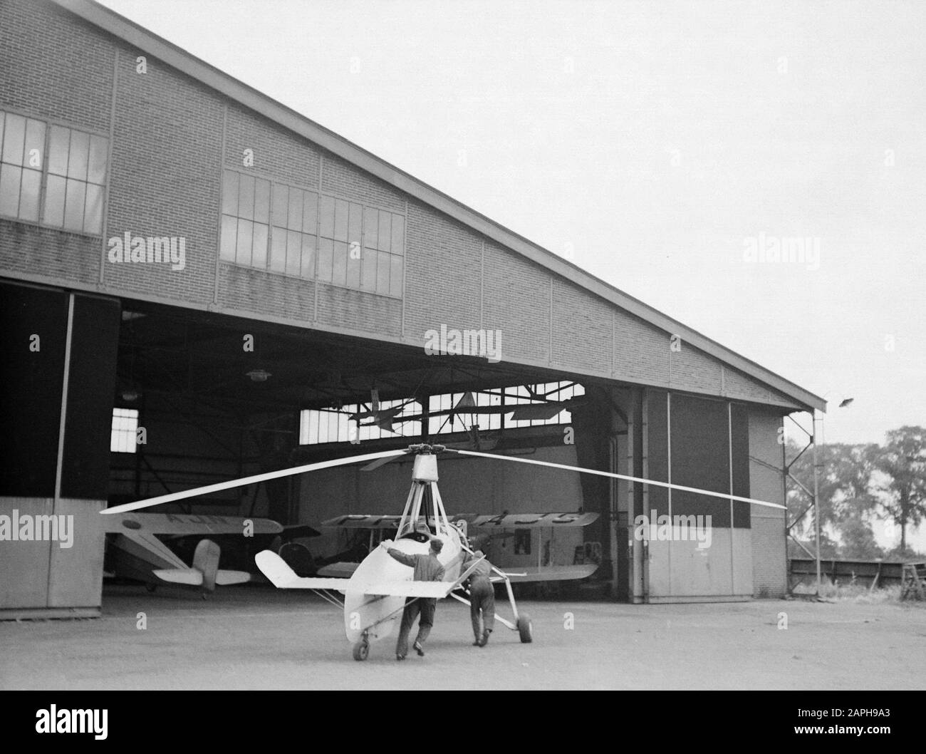 National Aviation School Holland Description: The Cierva autogiro PH-HHH (Donna Dulcinea) of the Dutch Aviation School the hangar at the Rotterdam airport Waalhaven is inserted Annotation: The Dutch Aviation School was based in Rotterdam Waalhaven and Amsterdam Schiphol Date: 1935 Location: Rotterdam, Waalhaven Keywords: special aircraft, hangars, flight training Personnel: Cierva, Juan de Stock Photo