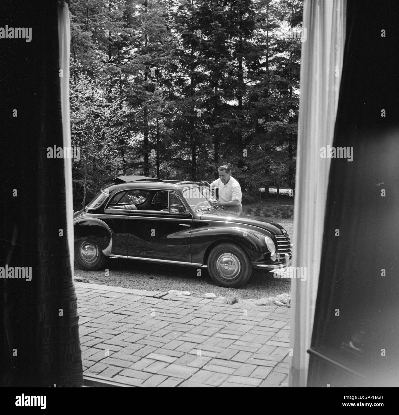 Eduard van Beinum at his country house Description: The conductor Eduard van Beinum washes the windshield of his open DKW at his country house Bergsham in Garderen Date: 5 June 1954 Location: Garderen, Gelderland Keywords: cars, conductors, exteriors, country houses Personal name: Beinum, Eduard van Stock Photo