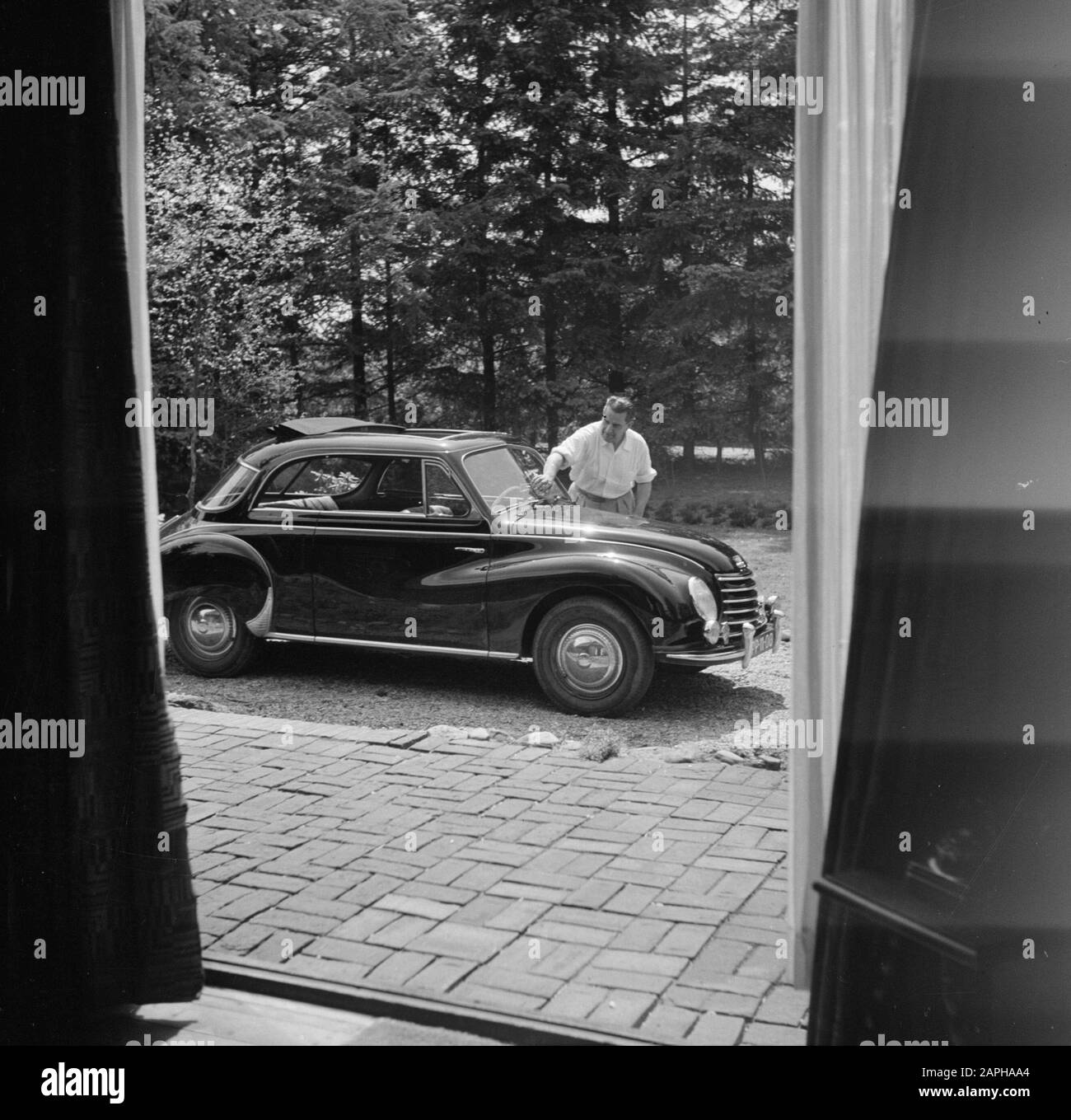 Eduard van Beinum at his country house Description: The conductor Eduard van Beinum washes the windshield of his open DKW at his country house Bergsham in Garderen Date: 5 June 1954 Location: Garderen, Gelderland Keywords: cars, conductors, exteriors, country houses Personal name: Beinum, Eduard of Stock Photo