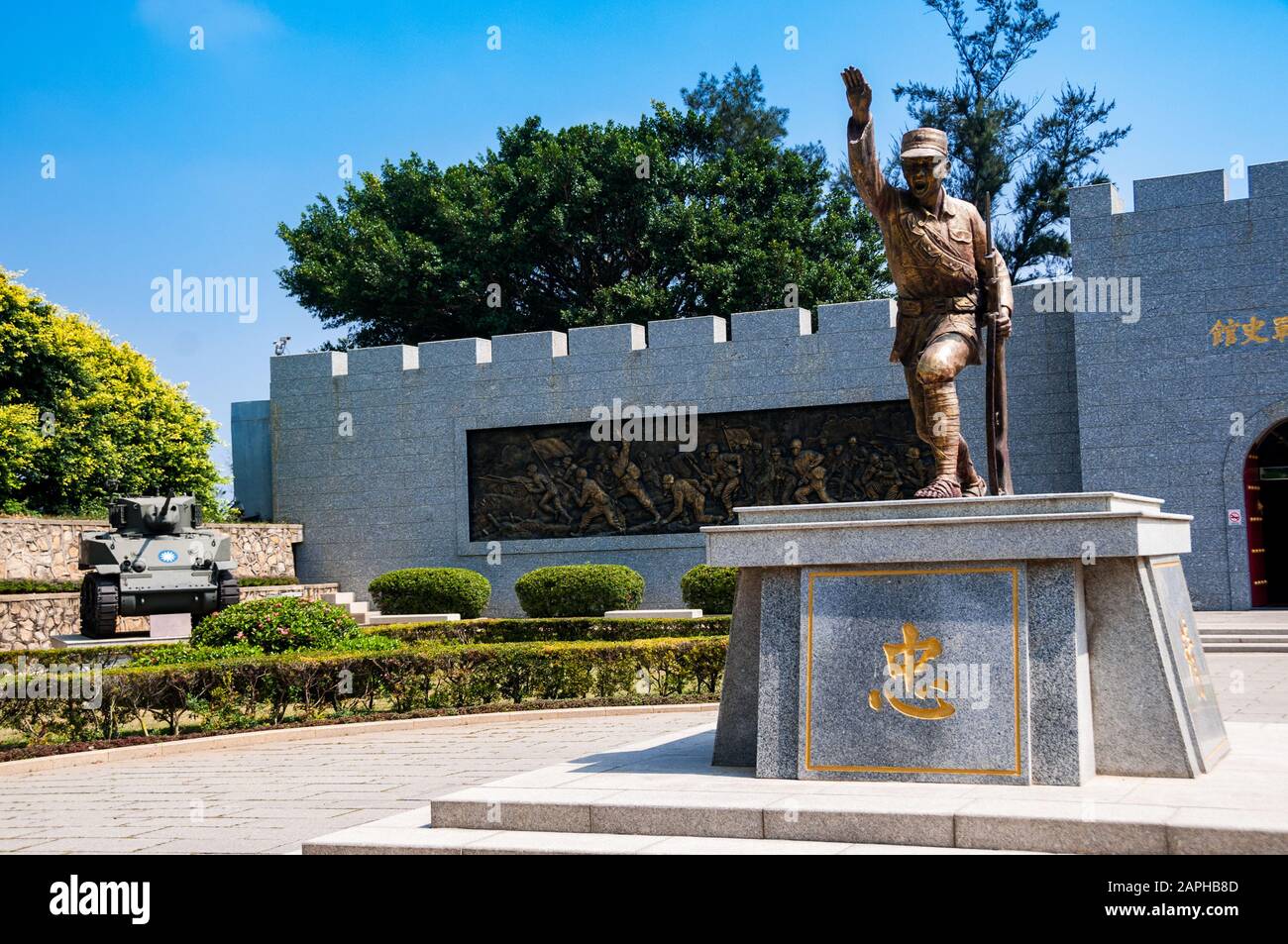 Statue of a soldier at the Guningtou War Museum on Jinmen Island with an M5A1 light tank behind. Republic of Taiwan (Taiwan). Stock Photo