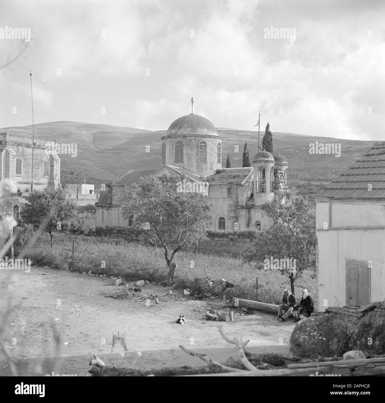 Israel 1948-1949: Kana Description: The Greek Orthodox Wedding Church, with in the foreground two villagers surrounded by scurrying chickens Date: 1948 Location: Israel, Cana Keywords: village statues, church buildings, chickens, towers Stock Photo