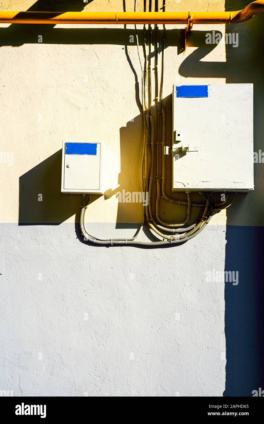Electrical switchboard on the wall. Hard shadows. Wiring to the