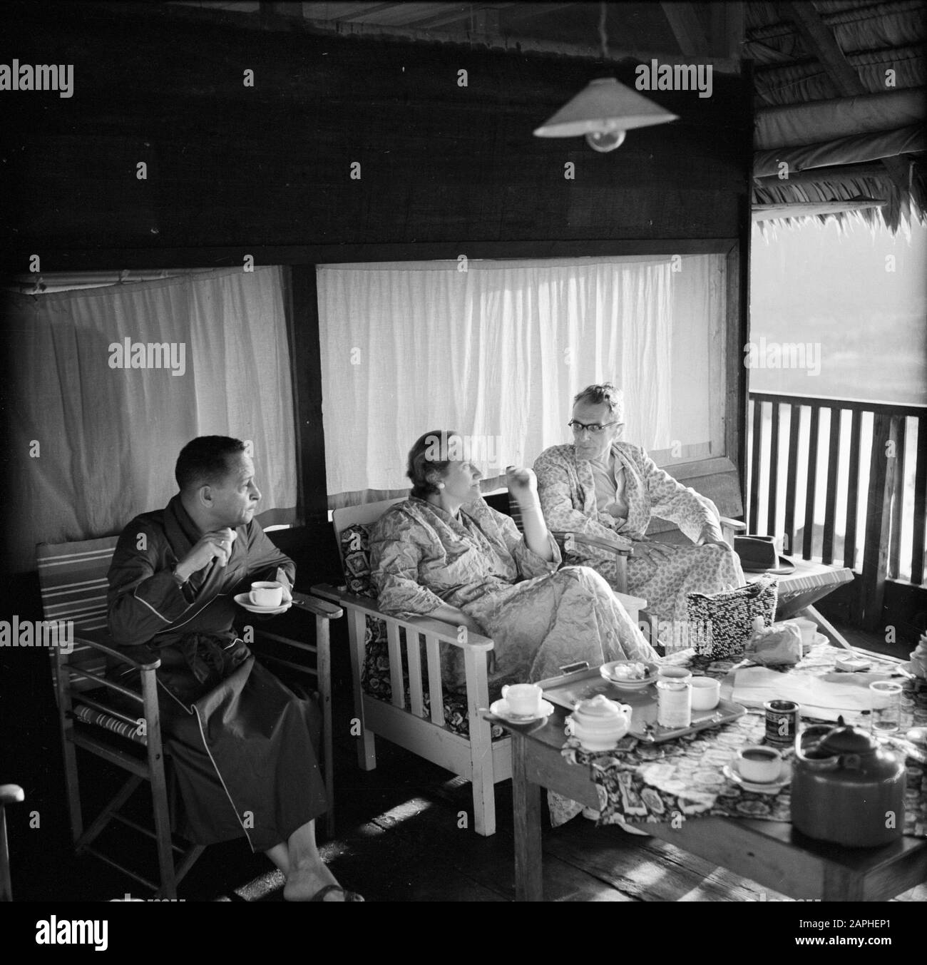 Dutch Antilles and Suriname at the time of the royal visit of Queen Juliana and Prince Bernhard in 1955 Description: Mr. Van Zuylen with Jo de Greve on the porch of the guest house in Brokopondo Date: October 1, 1955 Location: Brokopondo, Suriname Keywords: dwellings Personal name: Greve, Jo de, Zuylen, L. van Stock Photo