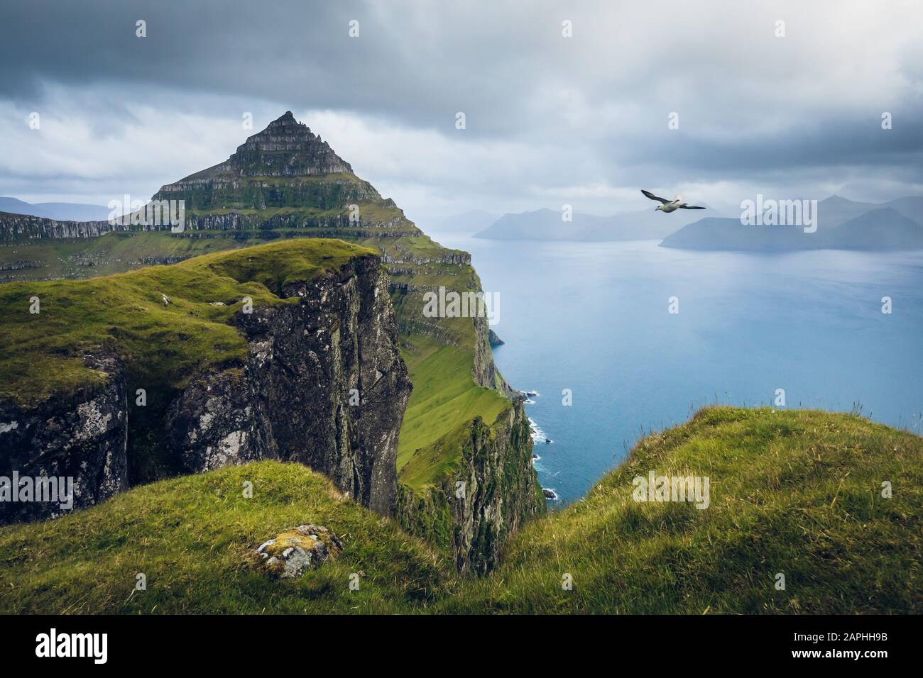 The view of the impressive cliffs of the island of Kalsoy from the top of Borgarin mountain. Faroe Islands Stock Photo
