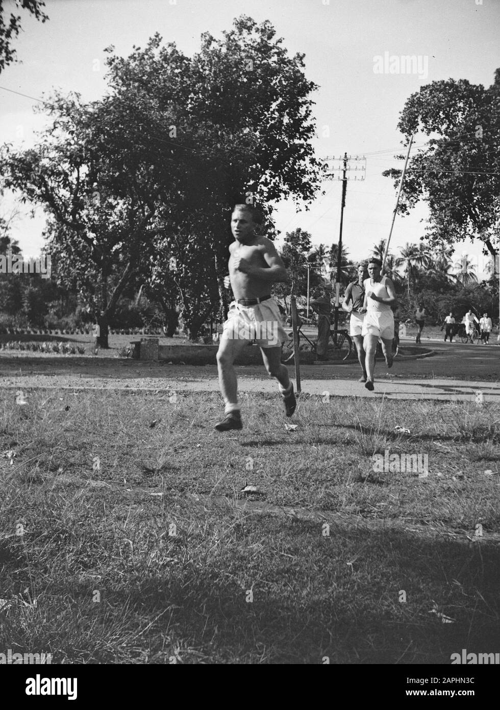 City run in Padang Description: The runners on the road Date: 9 May 1948 Location: Indonesia, Dutch East Indies, Padang, Sumatra Stock Photo