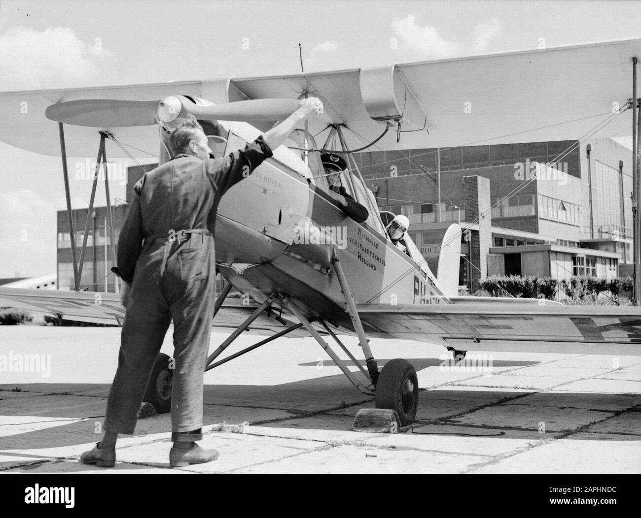 National Aviation School Holland Description: The mechanic strikes the screw of the Koolhoven FK-46 class aircraft because of his docile flying behaviour nicknamed 'Cow of Koebeest' of the National Aviation School Holland at Amsterdam Schiphol while instructor and adspirant pilot lean out of the cockpit Annotation: The National Aviation School Holland was based in Rotterdam Waalhaven and Amsterdam Schiphol Date: 1933 Location: Amsterdam, Rotterdam Keywords: students, teachers, mechanics, pilots, flight training, aircraft Personal name: Frits Koolhoven Stock Photo