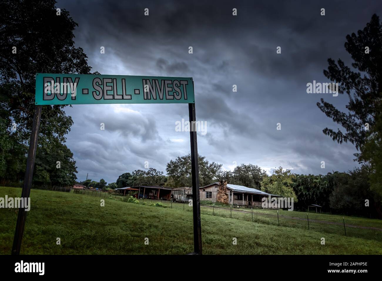 A Real Estate sign in a rural area of Florida tells you to buy, sell, or invest. Stock Photo