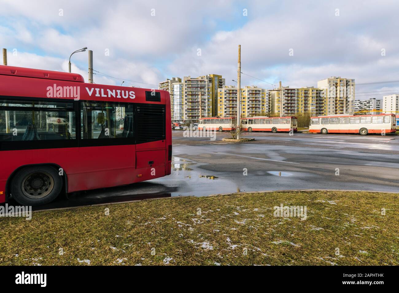 Red bus 'Vilnius' and trolleybuses in the distance Stock Photo