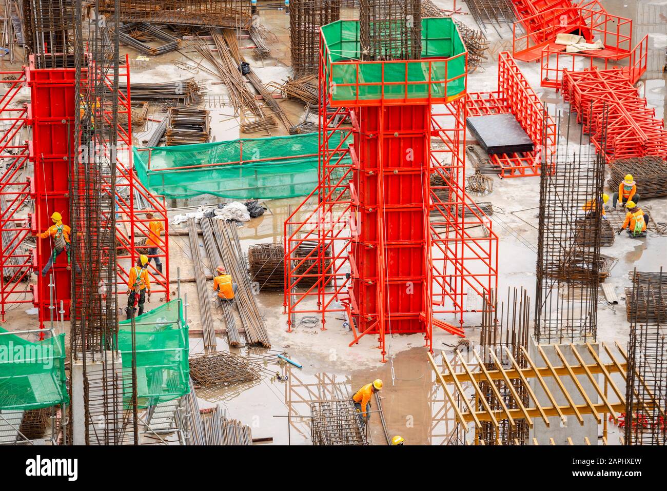 Aerial view of construction site workers with hooks for safety body harness. Building development concept. Stock Photo