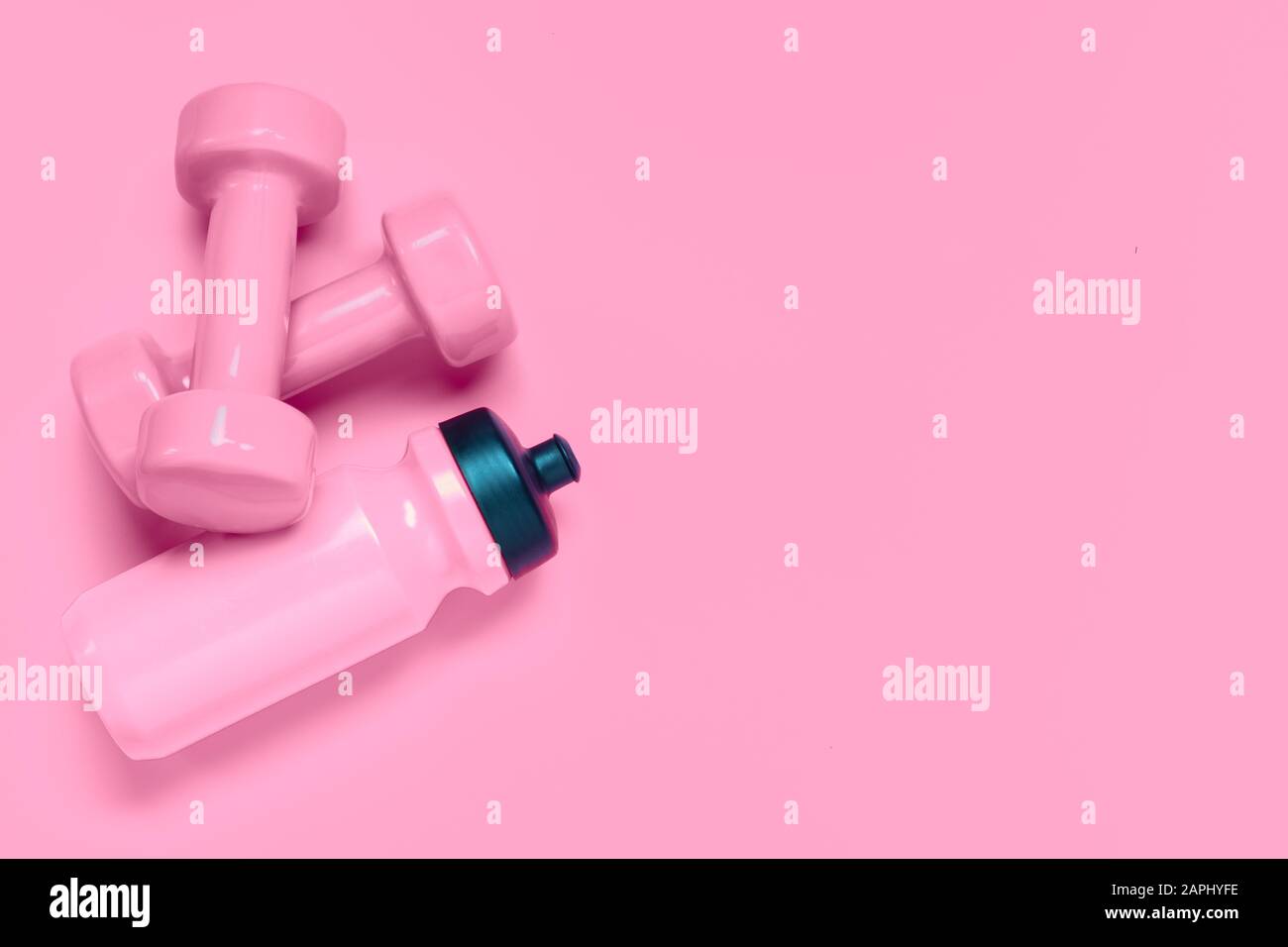 Fitness workout background concept with pink dumbbells and bottle