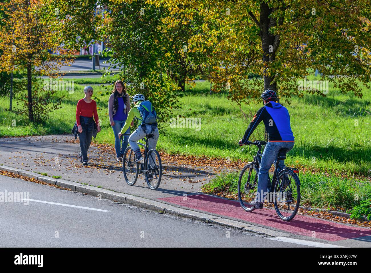 Cyclists changing from the cycle path to a combined cycling road and footpath with pedestrians Stock Photo