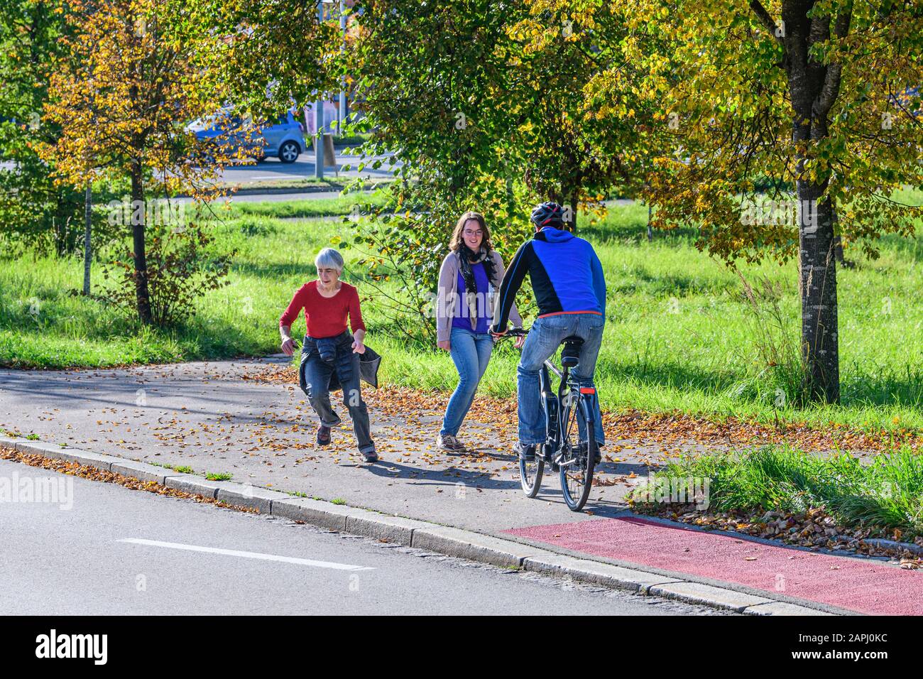 Cyclists changing from the cycle path to a combined cycling road and footpath with pedestrians Stock Photo