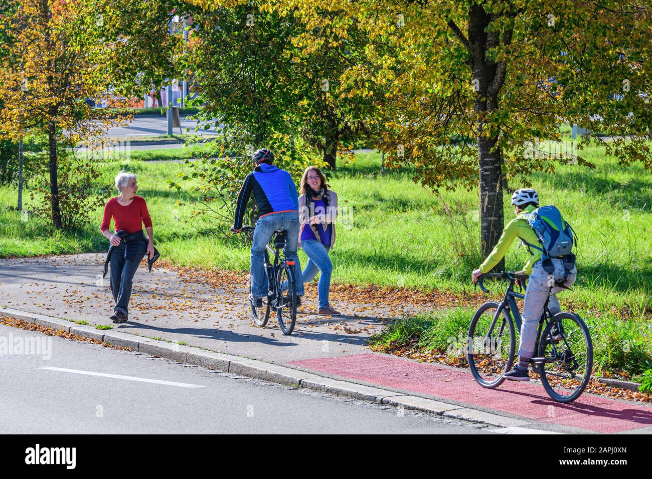 Cyclists changing from the cycle path to a combined cycling road and footpath with pedestrians Stock Photo