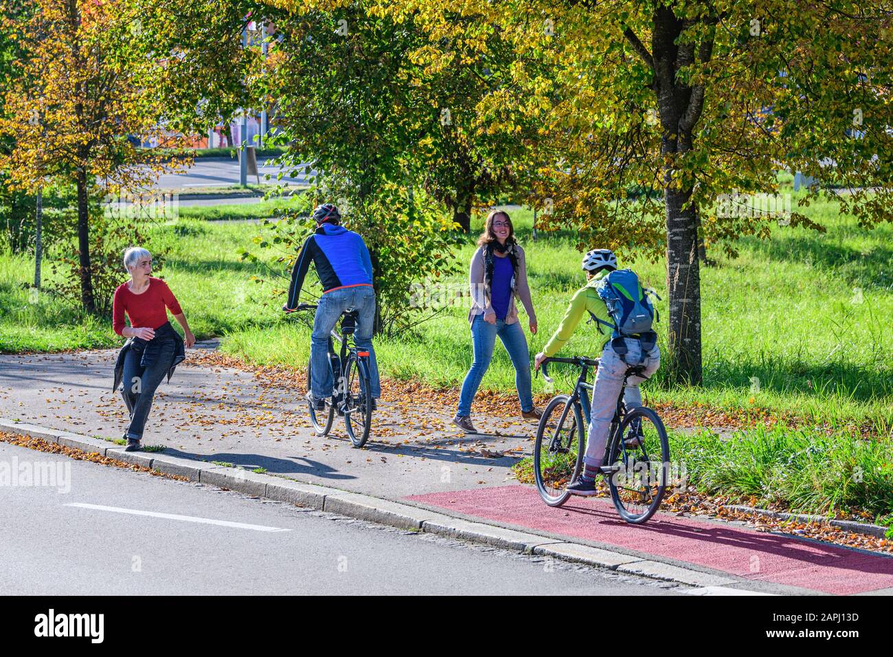 Cyclists changing from the cycle path to a combined cycling road and footpath with pedestrians Stock Photo