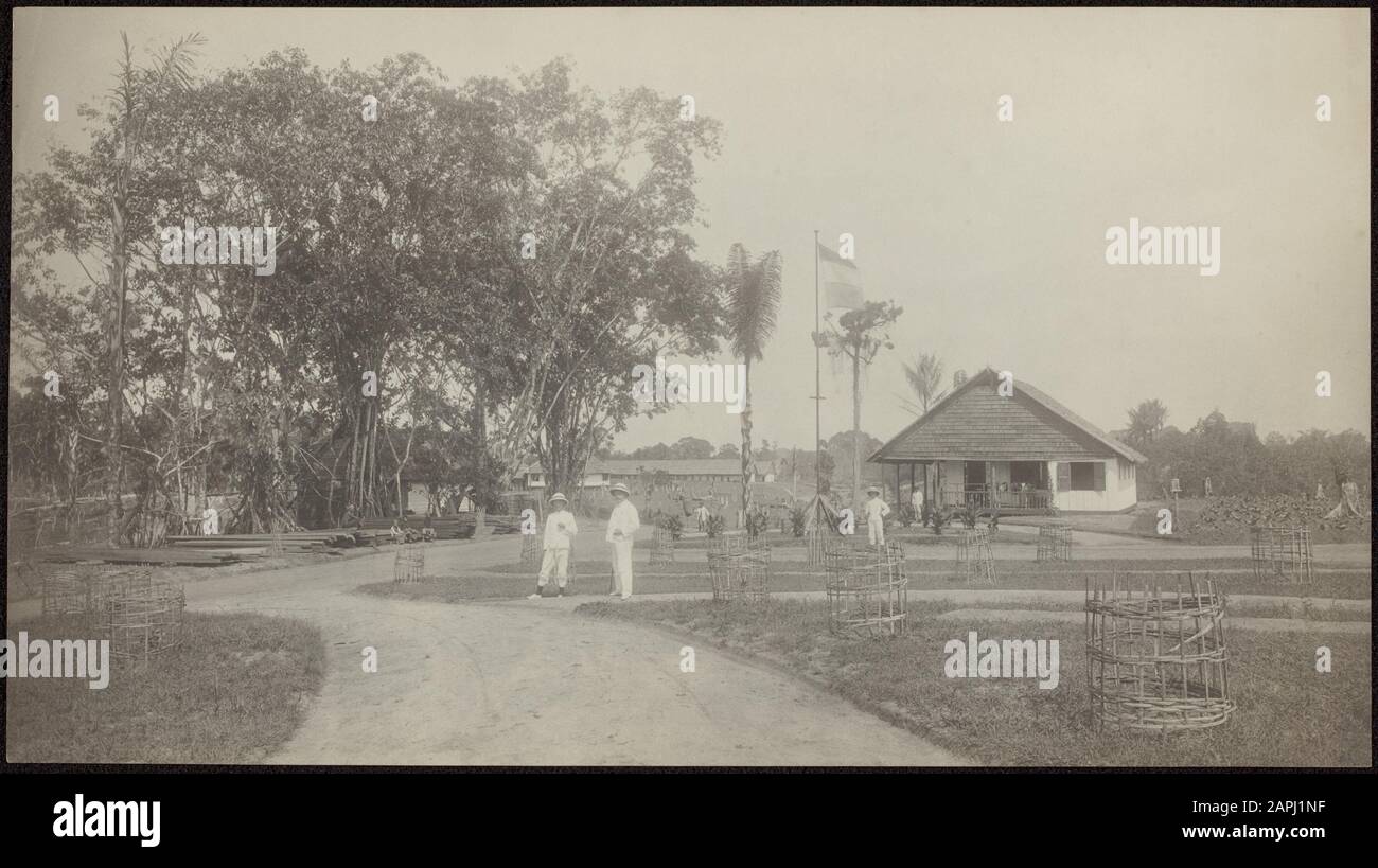 A tobacco company in Deli Sumatra Description: The garden of the administrator's house and other houses; men in tropical costume posing, the Dutch flag is hoisted Annotation: Part of the garden of the administrator's house with office, assistant house, nsitters house and background Javanen pondoks Date: 1867 Location: Deli, Indonesia, Dutch East Indies, Sumatra Keywords: men, plantations, tobacco plantations, tropics, gardens, flags, homes Stock Photo