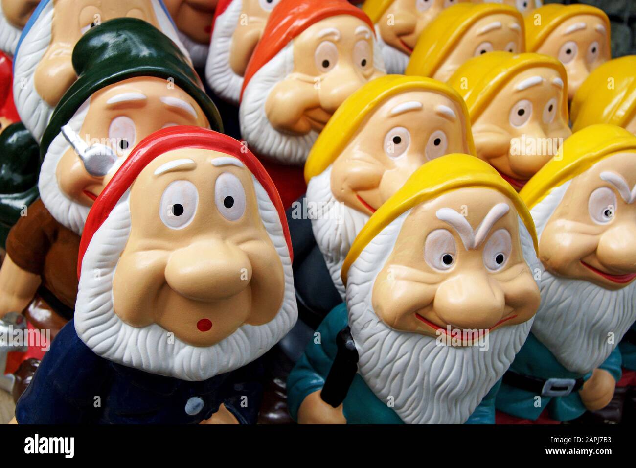 Close up of garden gnomes in a garden centre with the one at the front with a look of surprise, Stock Photo