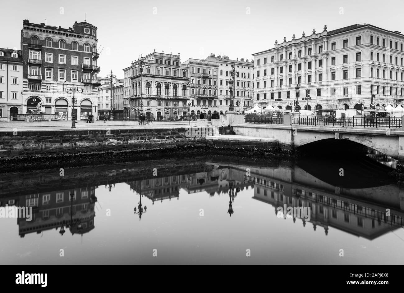 Trieste - December 2016, Italy: Old historical buildings mirror reflected in water, Grand Canal in Trieste city center, black and white cityscape Stock Photo