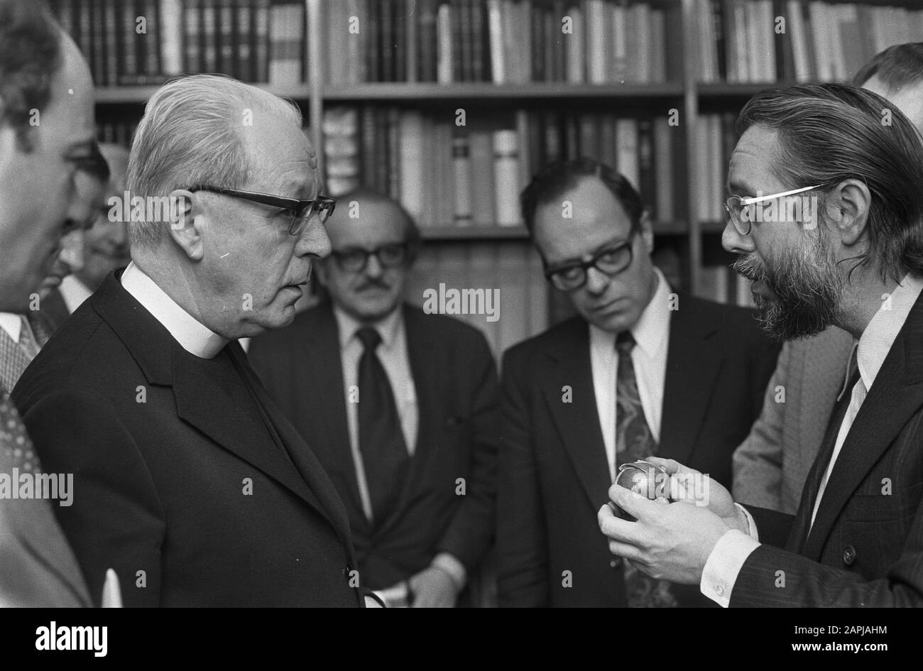 Delegation of American Council of Churches speaks with Cardinal Alfrink in Rotterdam about Vietnam, Harvey Cox (r) shows fragmentation bomb to Cardinal Alfrink (r) Date: January 9, 1973 Location: Rotterdam, Zuid-Holland Keywords: discussions, delegations, cardinals Personal name: Alfrink, Bernardus Institution name: Council of Churches in the Netherlands Stock Photo