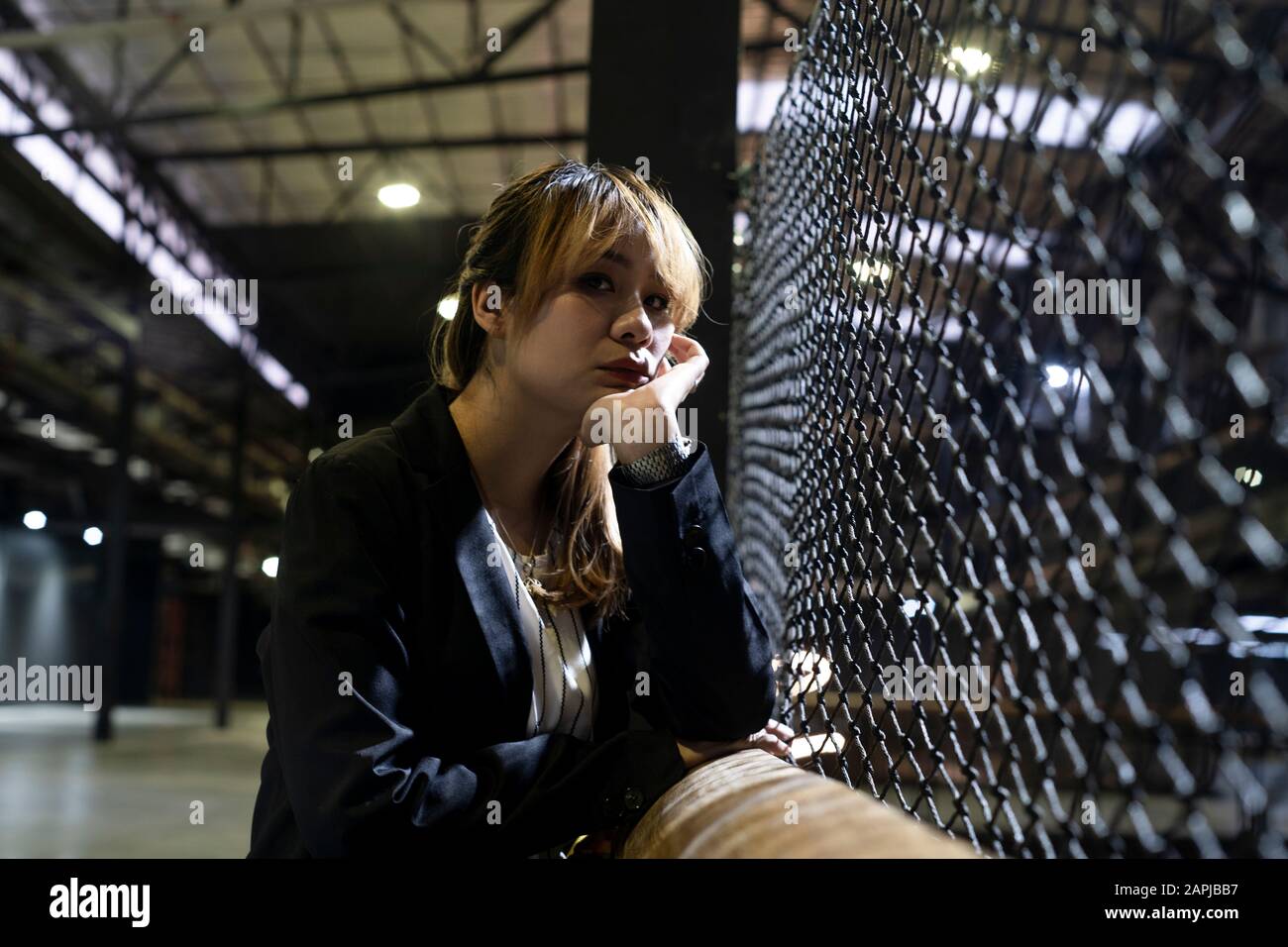 Loneliness blond hair woman standing at the fence under the light prop ...