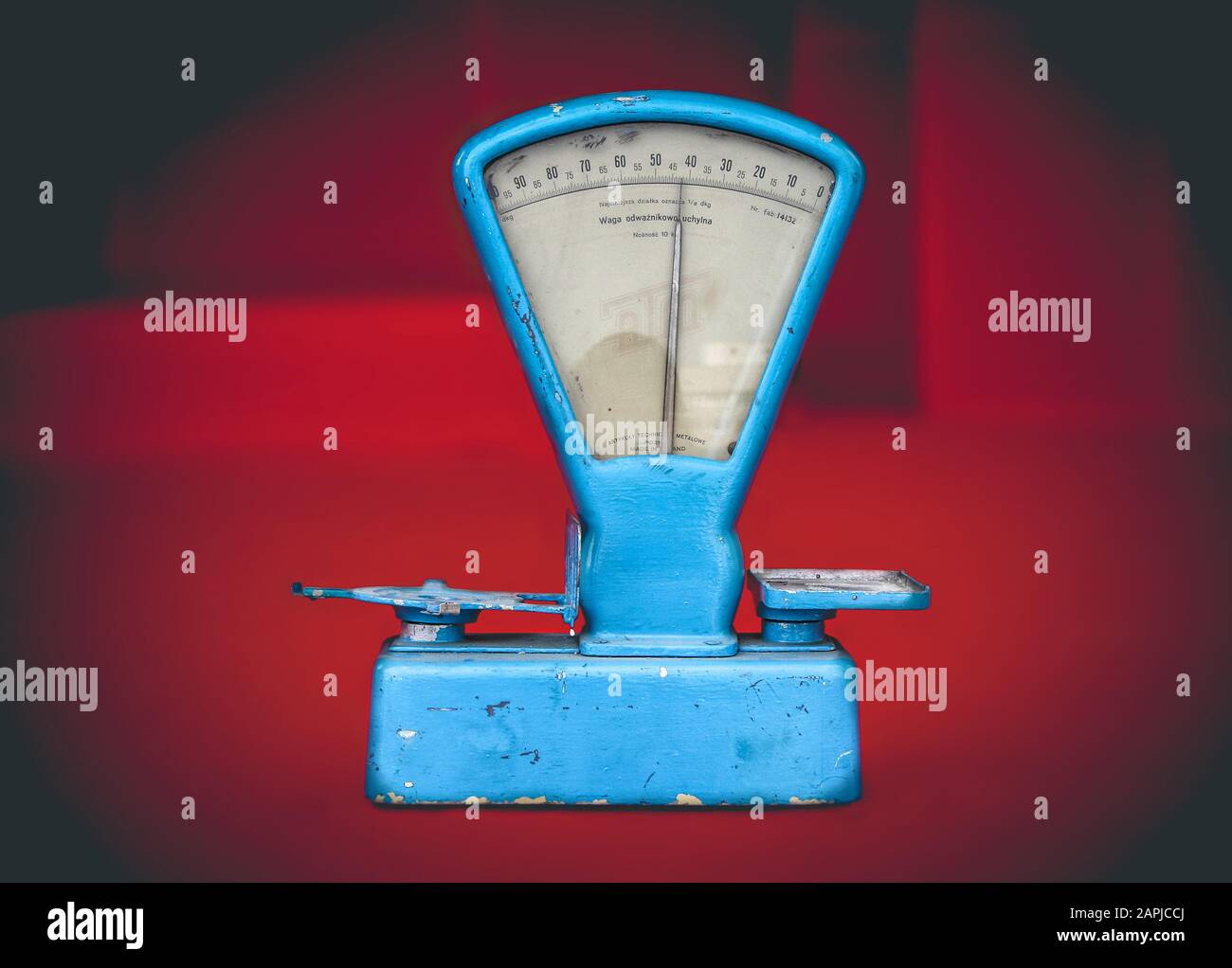Vintage weathered blue food weighing scale on red background, souvenir of  the communism era in Poland Stock Photo - Alamy