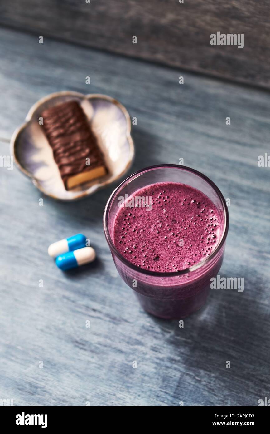 Glass of Protein Shake with milk and blueberries, Creatine capsules and Protein  bar. Concept for Sport nutrition Stock Photo - Alamy