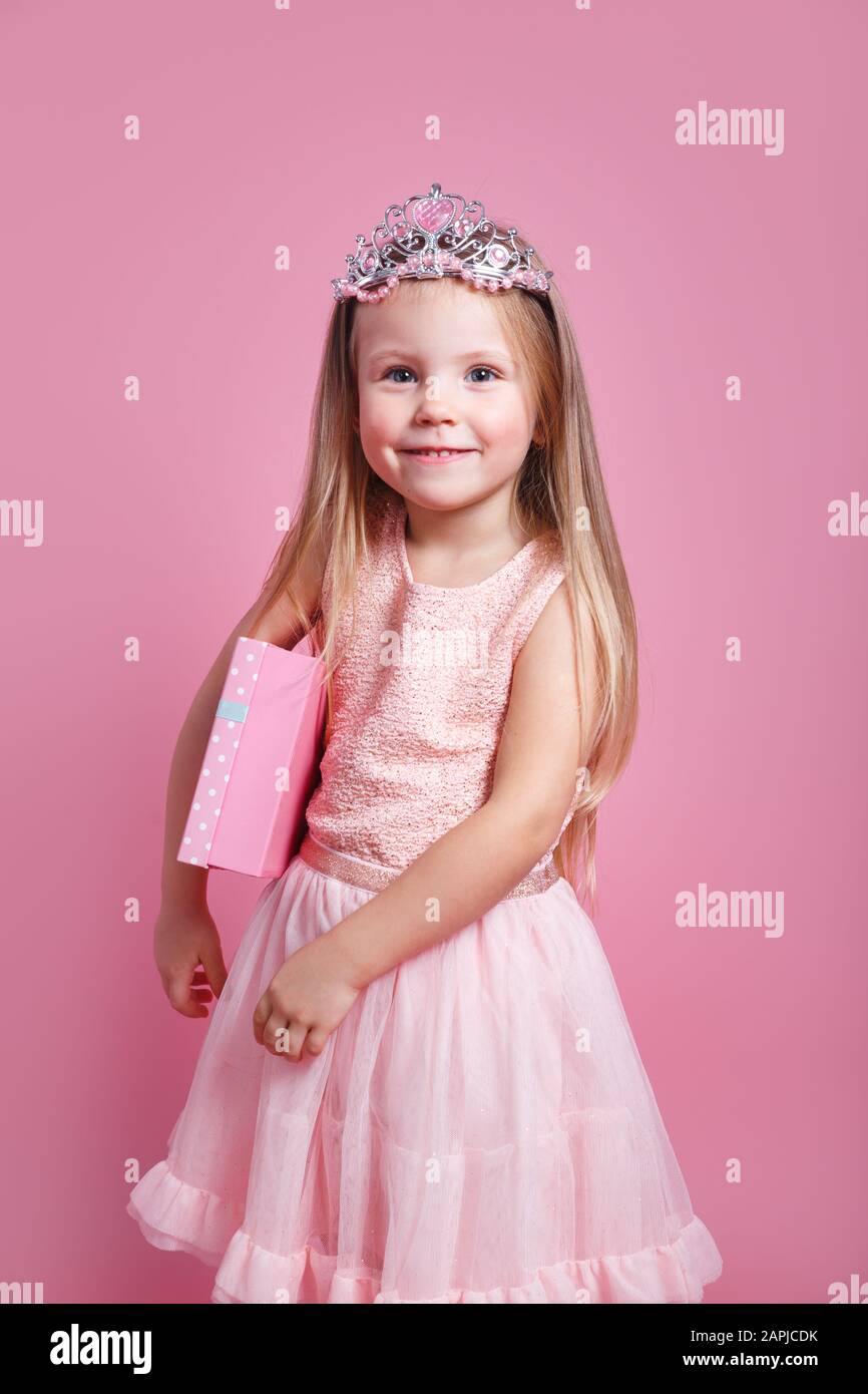 Portrait of cute smiling little girl with gift box in princess dress