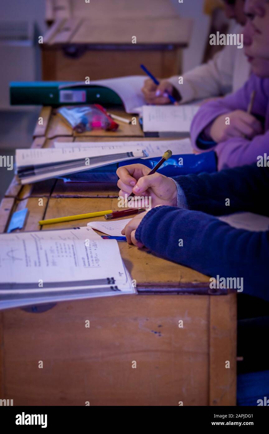 Pupil working in classroom Stock Photo