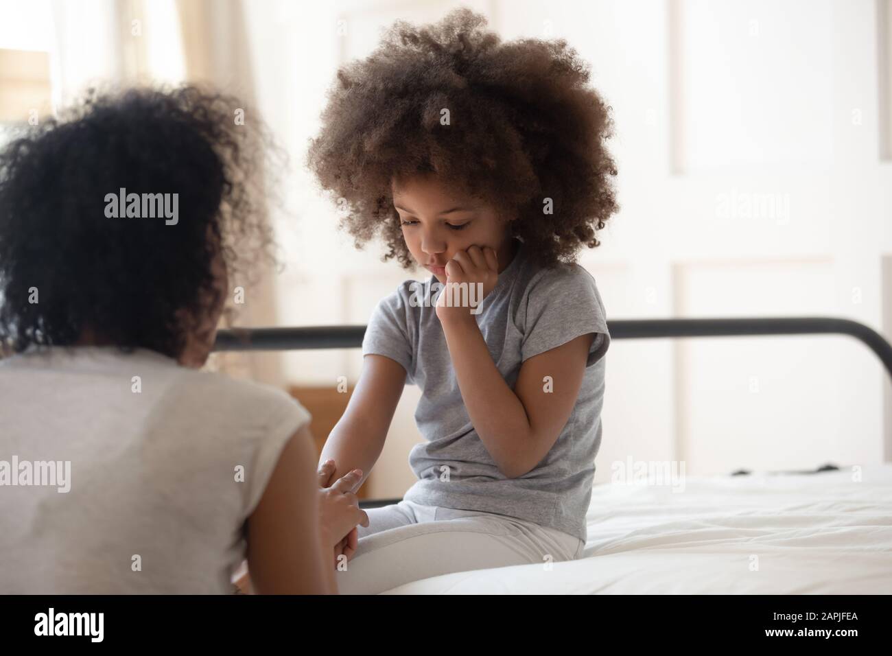 African mother holds hand of little daughter talks gives support Stock Photo