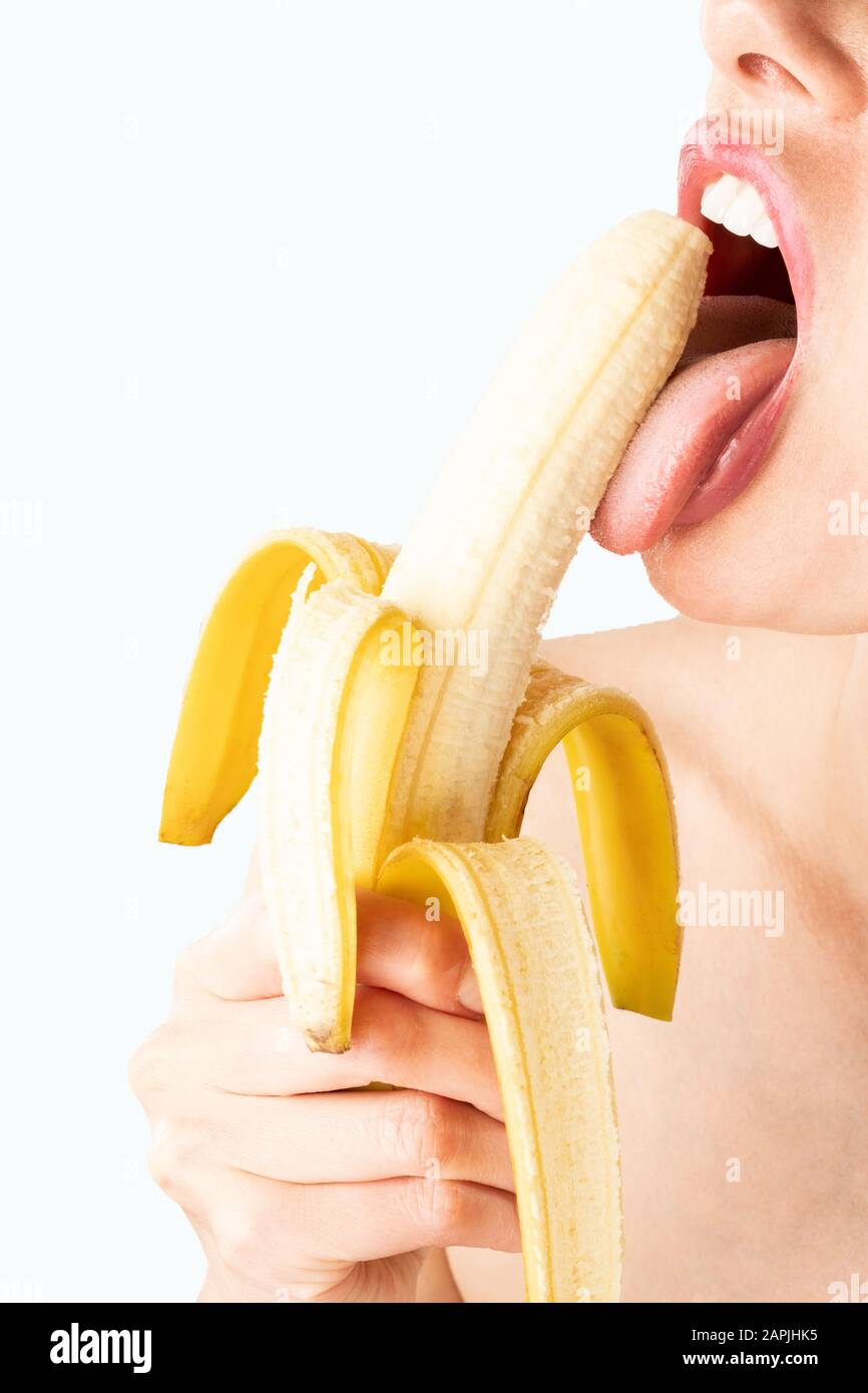 Close-up of sexy woman eating banana isolated on blue Stock Photo - Alamy