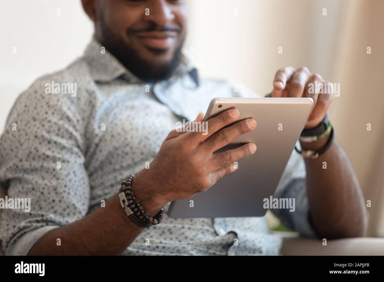 Close up focus of african male hands holding tablet computer Stock Photo