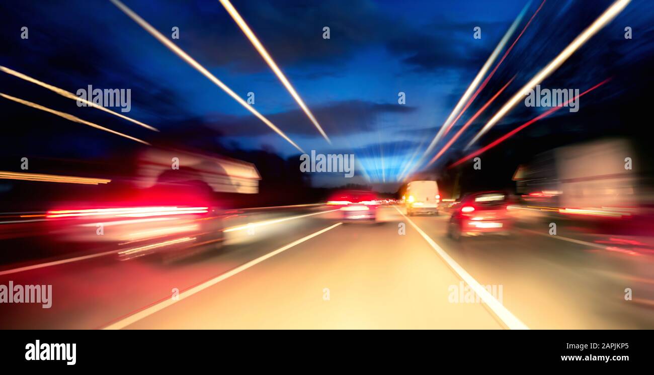 Driving fast on the highway or German Autobahn at night, cars and lights with motion blur Stock Photo