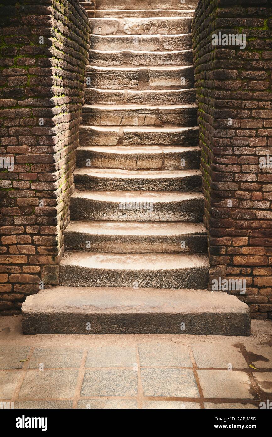 Ancient stone stairs with brick wall aside. Stock Photo