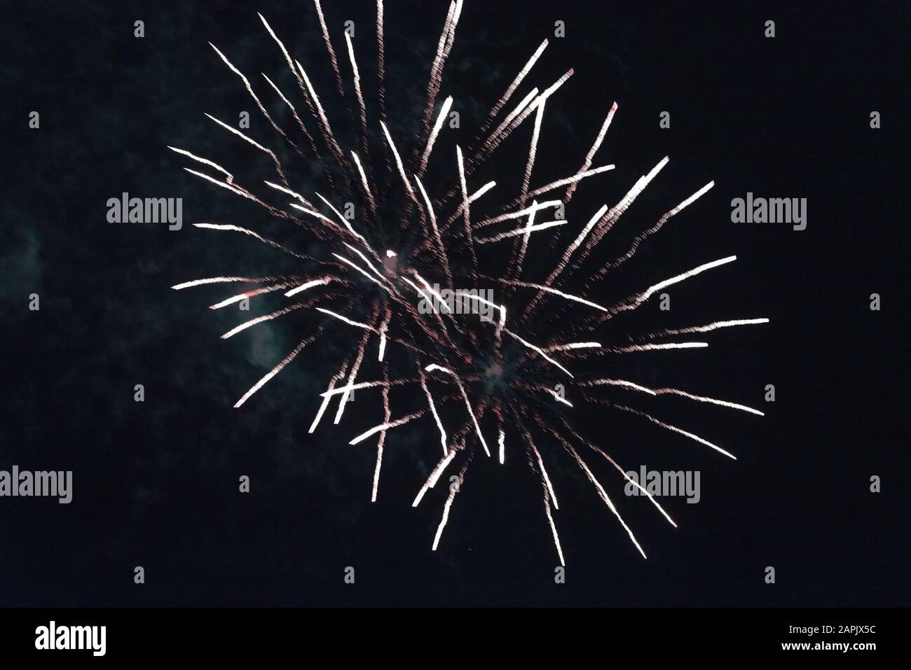Cheap white fireworks against the dark sky. Stock Photo