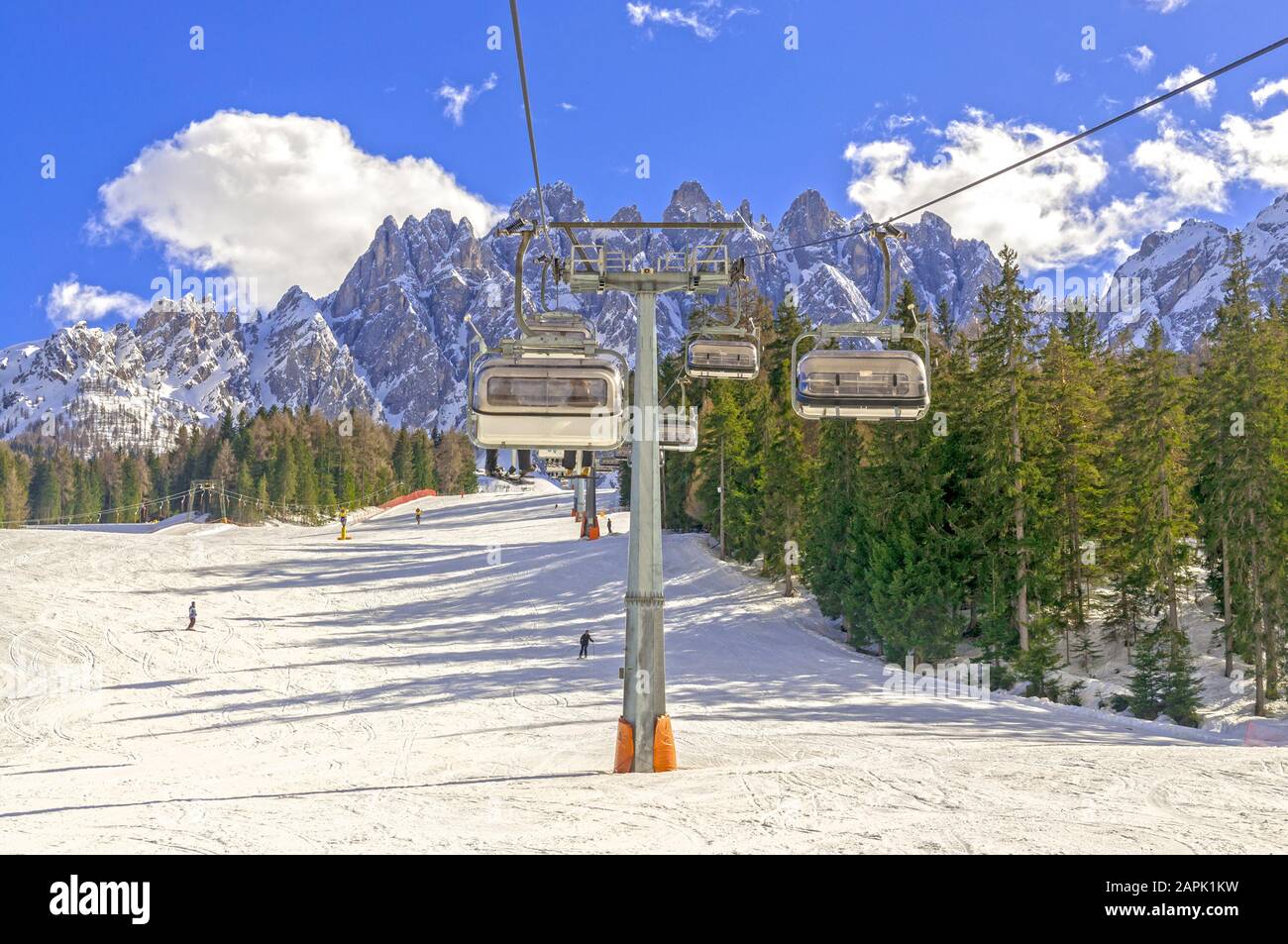 Winter landscape in Dolomites, ski slope with cable lift in San Candido with mountain range in background Stock Photo