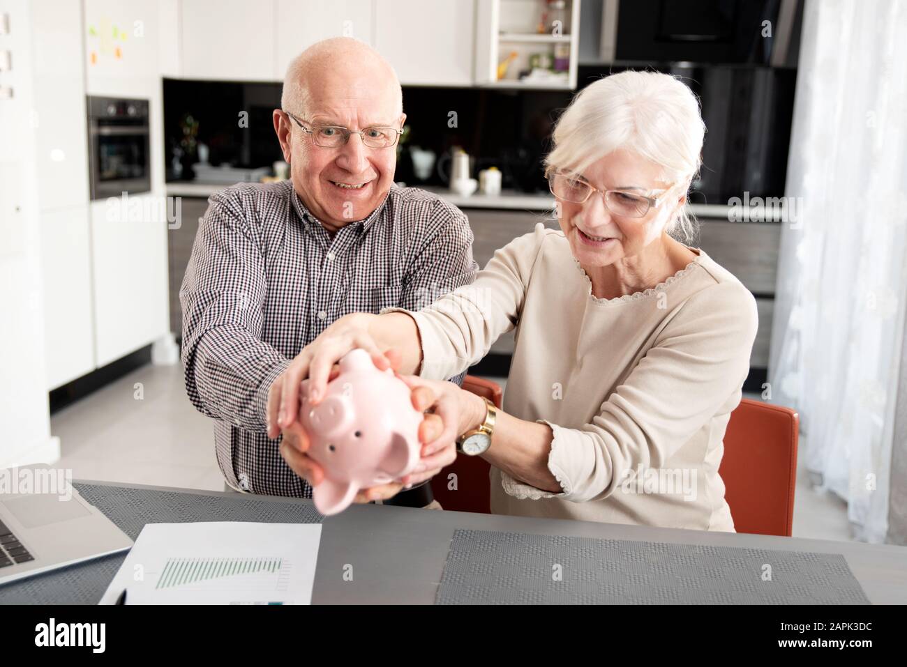 Senior couple is trying to get the savings out of the piggy bank Stock Photo