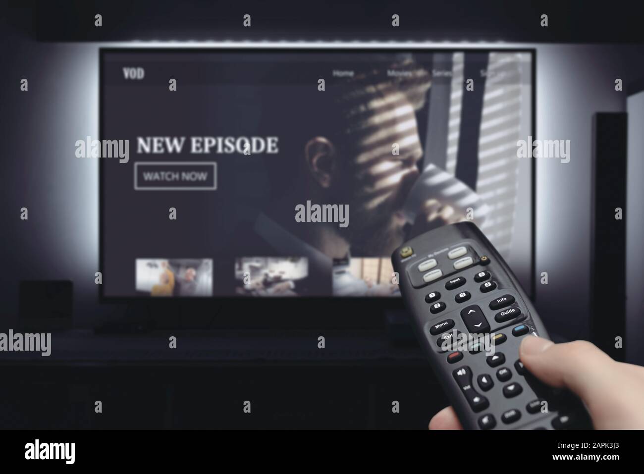 VOD service on television. Man watching TV, streaming service, video on demand, remote control in hand. Stock Photo