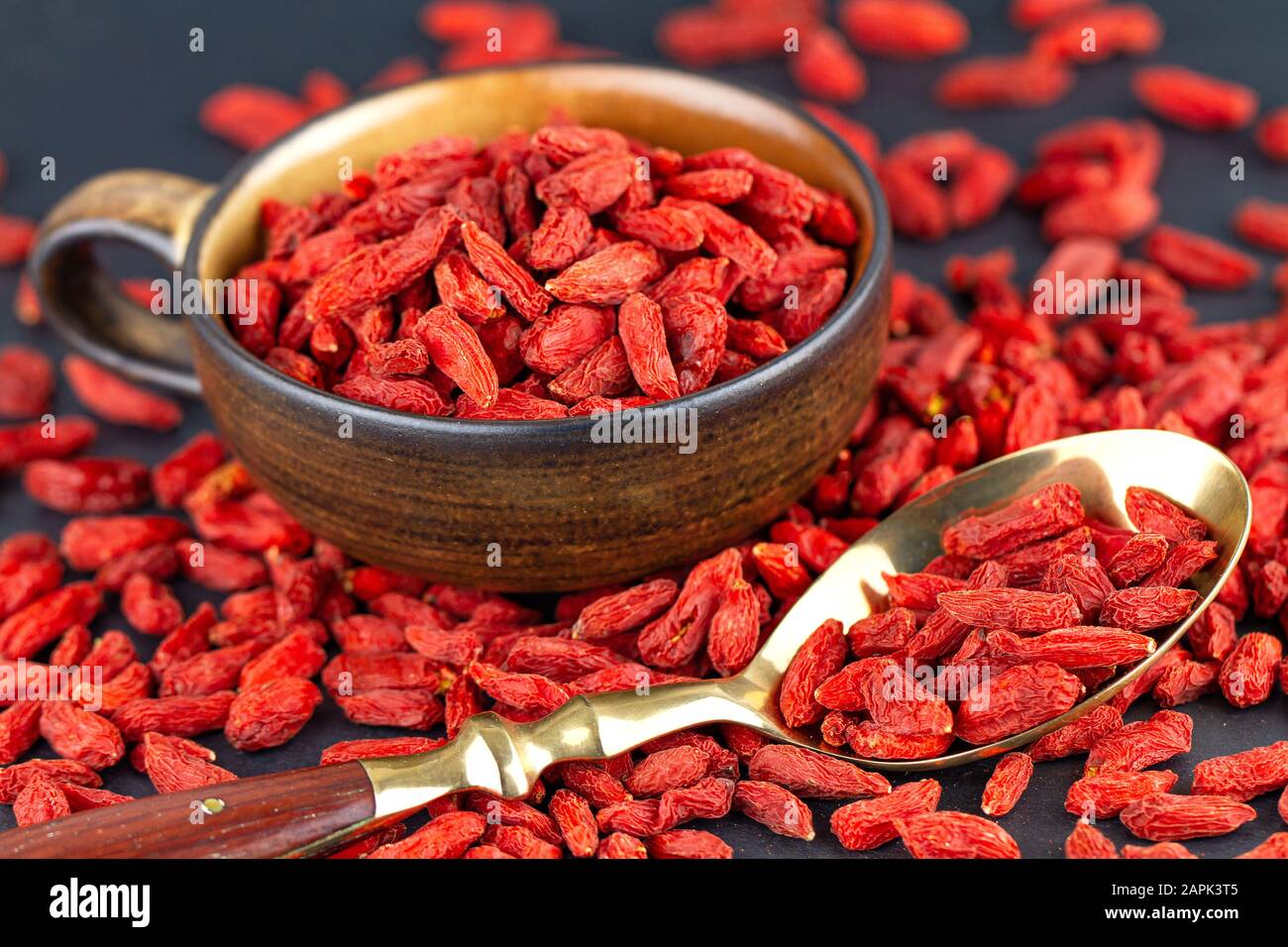 Goji berries in cup with vintage spoon on gray slate. View from above, selective focus Stock Photo