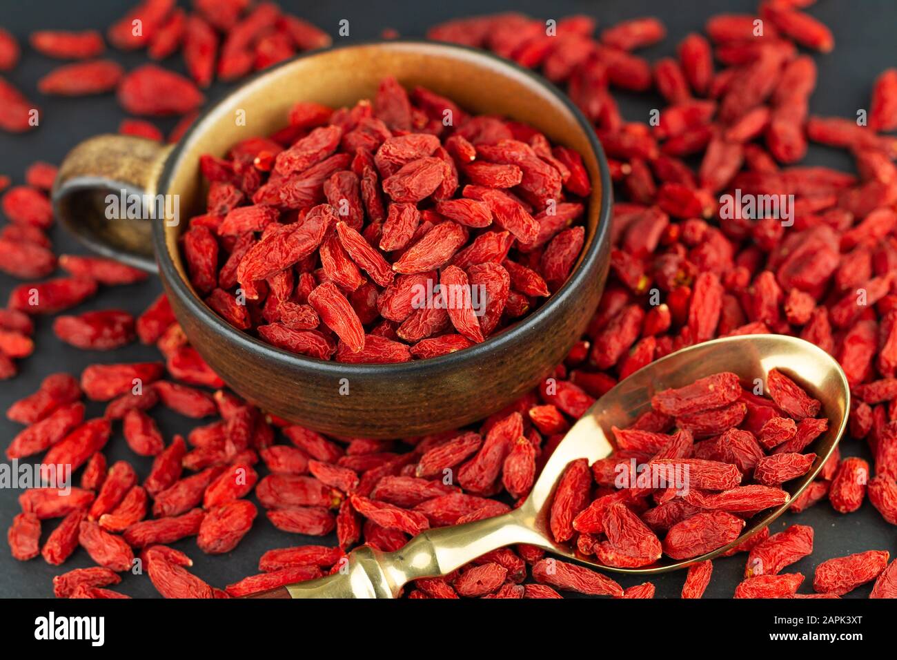 Cup with Goji berries and vintage spoon on gray slate. View from above, selective focus Stock Photo