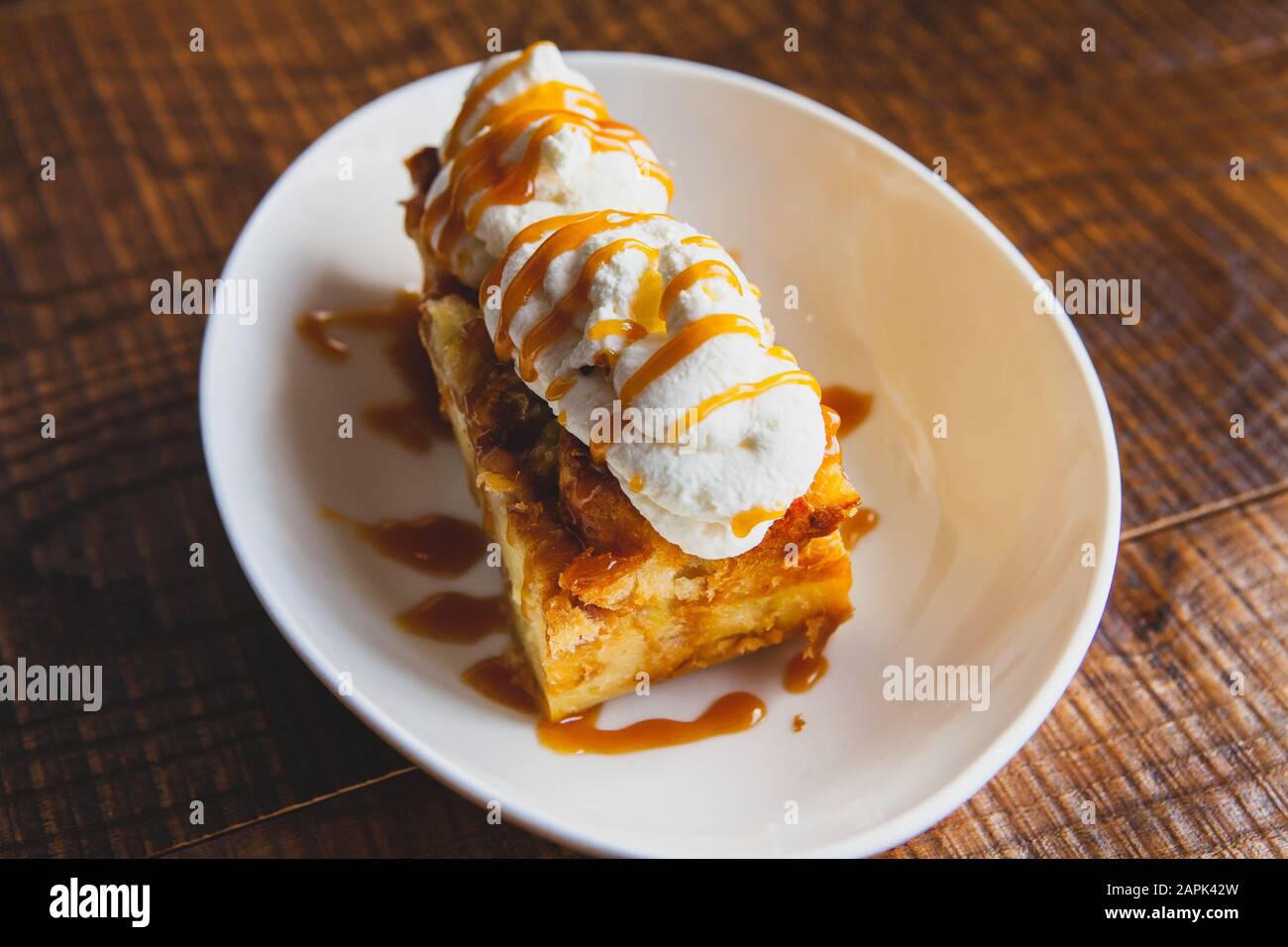 Bread pudding dessert sitting on a wooden table. Stock Photo