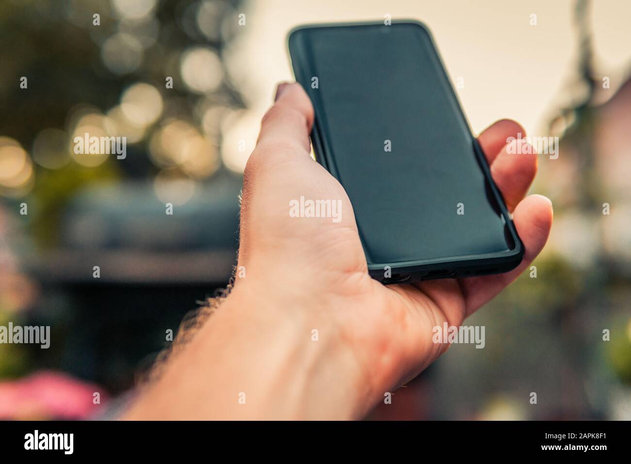 Male hand holding black smartphone Stock Photo